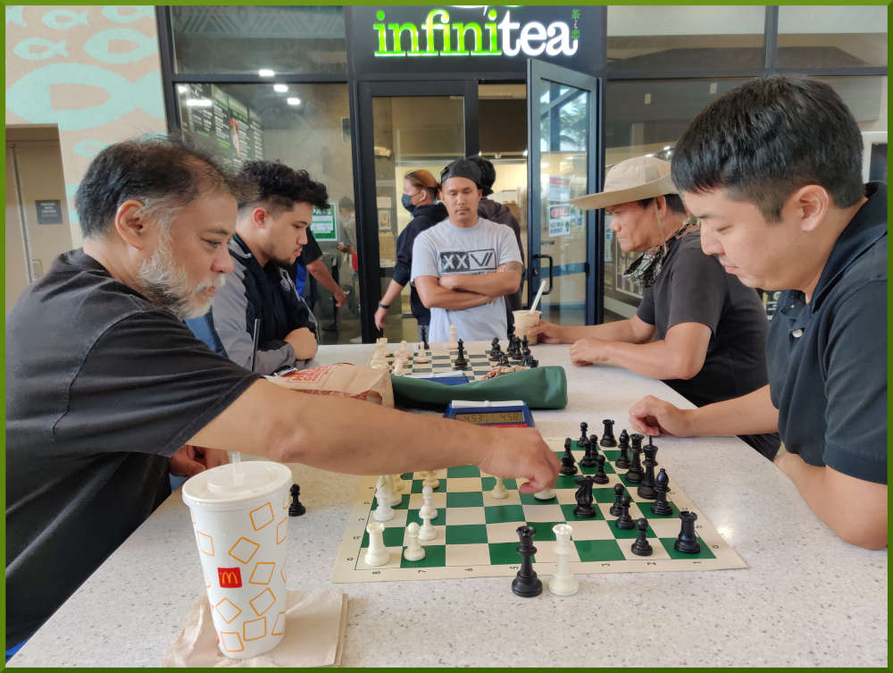 April 5th, 2022. Ka Makana Alii chess meetup. Chet vs Shaun (near board). Christian vs guy in hat (far board). Shane waits for his turn.