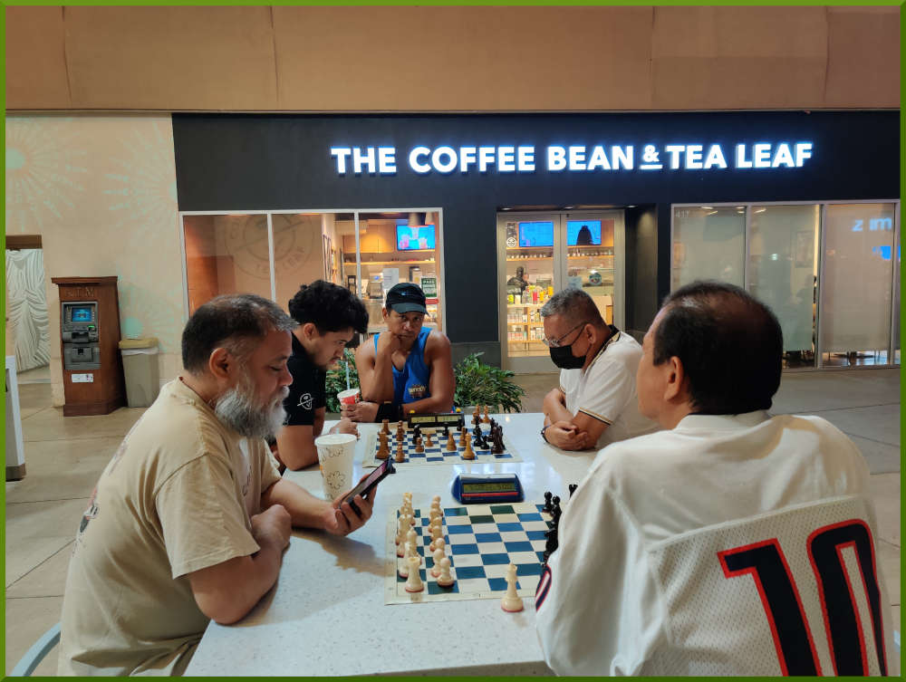 July 19th, 2022. Ka Makana Alii chess meetup. Chet waits for an opponent (near board). Christian vs Ceasar (far board).