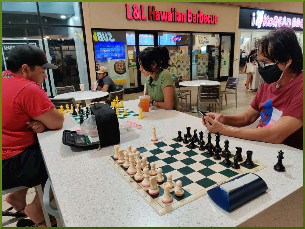 August 16th, 2022. Ka Makana Alii chess meetup. Regie waiting for an opponent (near board). Ceazar vs Mckenzie (far board).